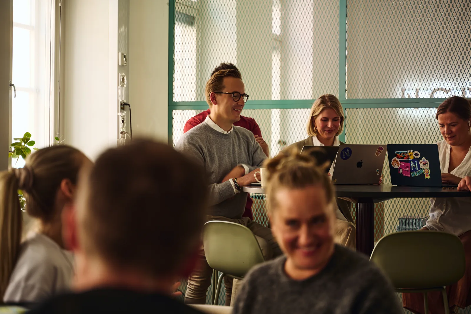 NØRR3 colleagues in a lively meeting-room discussion in the Helsinki studio